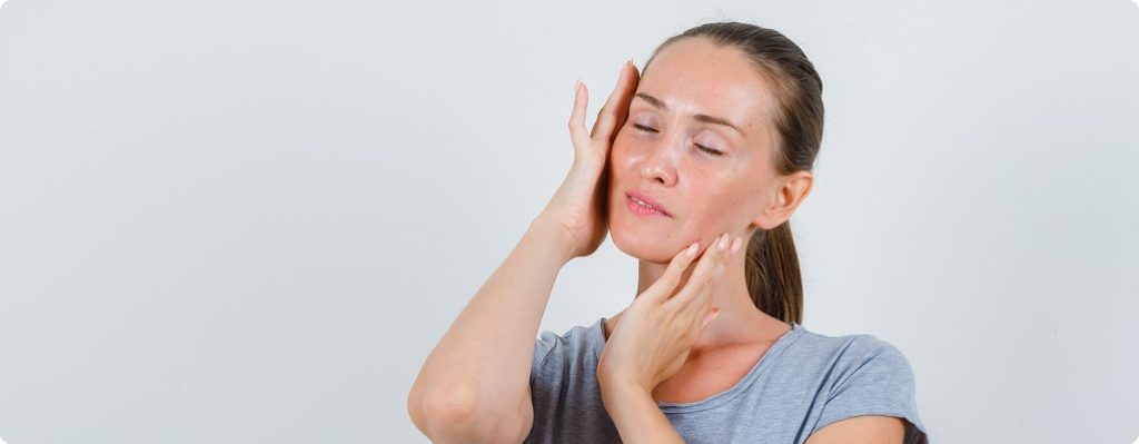 una mujer masajeando su rostro suavemente
