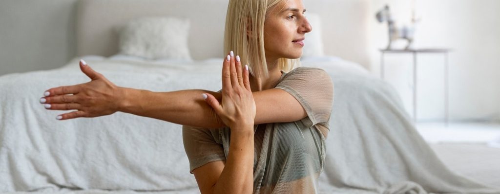 una mujer estirando su brazo para yoga